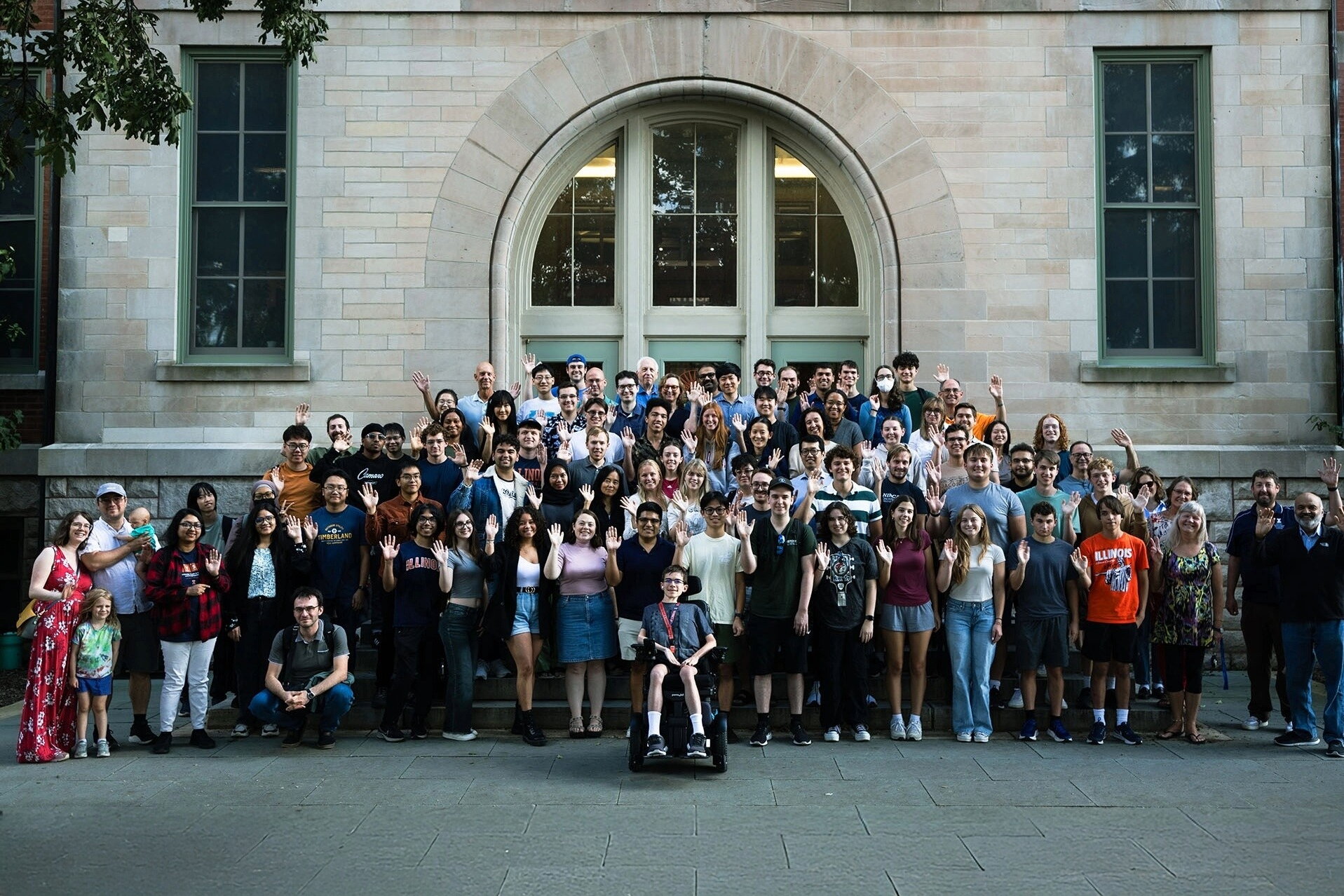 Students waving in front of the Natural History Building.