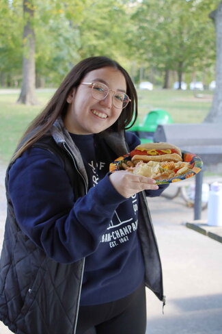 Student posing with picnic food