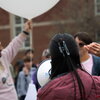 A student ready to launch a weather balloon as another talks into a megaphone.